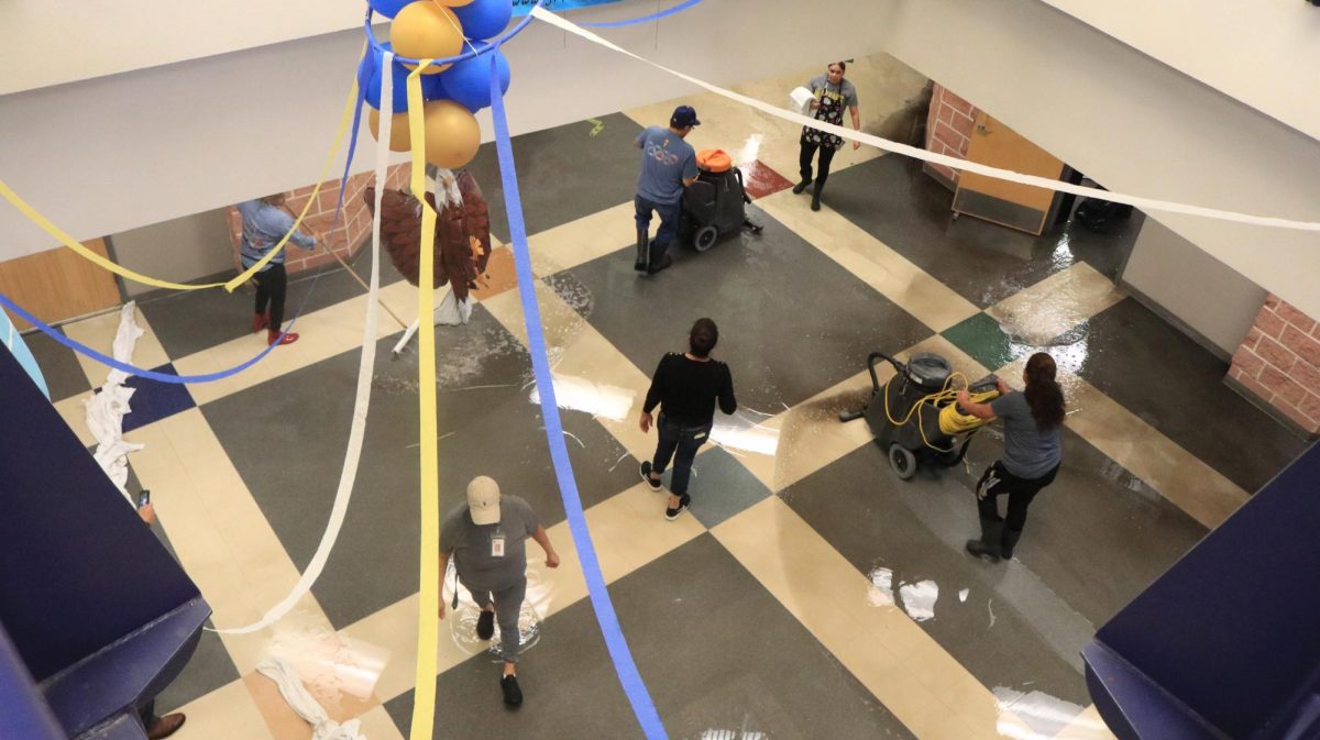 The Akins custodial staff cleans up water that poured ouf of an AC waterline, flooding classrooms in the Green Hall on Oct. 17. 