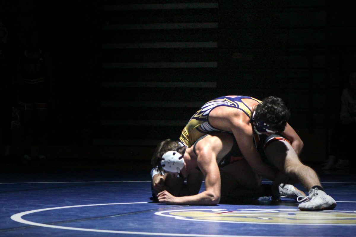 Junior Don Miles wrestles during Senior Night underneath the recently installed spotlight.