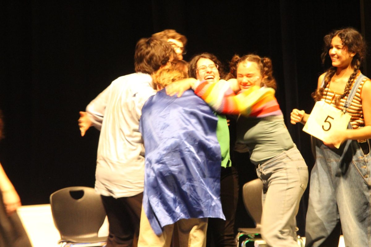 Theater students hug Ash Lopez on the stage in the auditorium on April 25th 2025