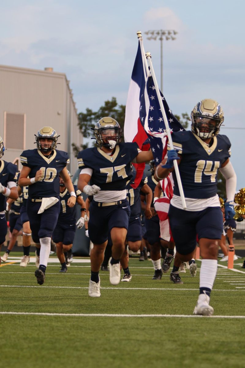 Cruz Morales (14) leads the Akins Eagles out of the tunnel for their homecoming game against the Northeast Raiders.