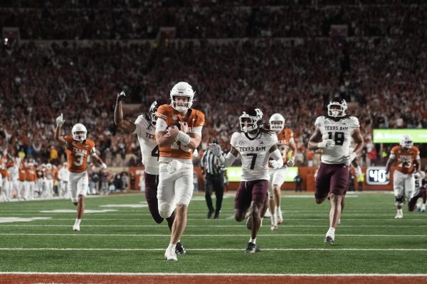 Nov 28, 2025; Austin, Texas, USA; Texas Longhorns quarterback Arch Manning keeps the ball and runs for a touchdown during the second half against the Texas A&M Aggies at Darrell K Royal-Texas Memorial Stadium. Mandatory Credit: Scott Wachter-Imagn Images