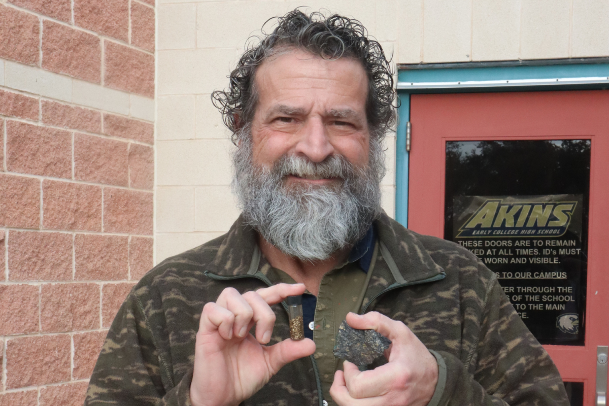 Teacher Jeff Schafer shows off a vial of gold flakes and a hunk of ore with embeded gold. Schafer spends his summer mining gold in Nevada. He often carries these items in his pocket at work, ready to show students and colleagues the tangible rewards of his labor.